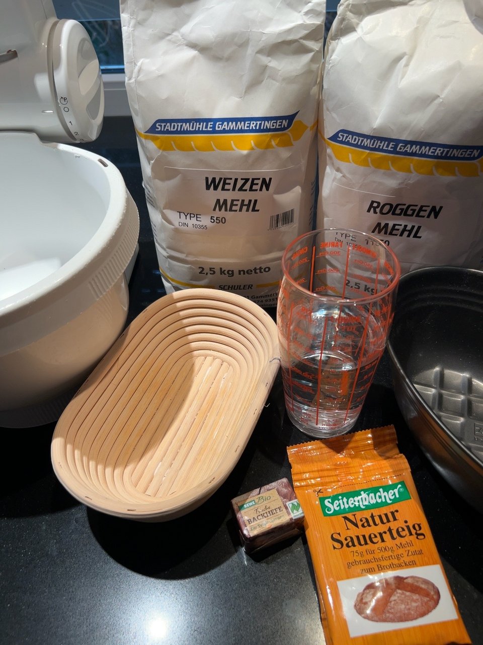 Weizenmehl, Roggenmehl, Natursauerteig, Hefe, Wasser, Rührschüssel und Gärkörbchen