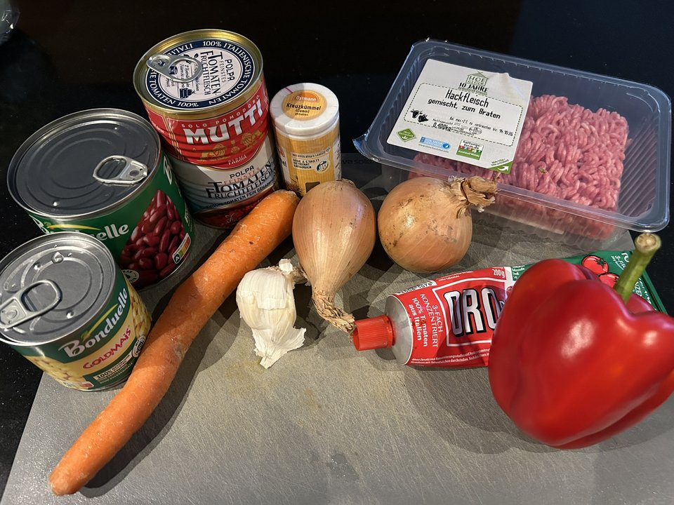 Gemischtes Hackfleisch, Tomaten, Kidneybohnen, Mais, rote Paprika, Möhre, Zwiebeln, Knoblauch, Tomatenmark und Kreuzkümmel