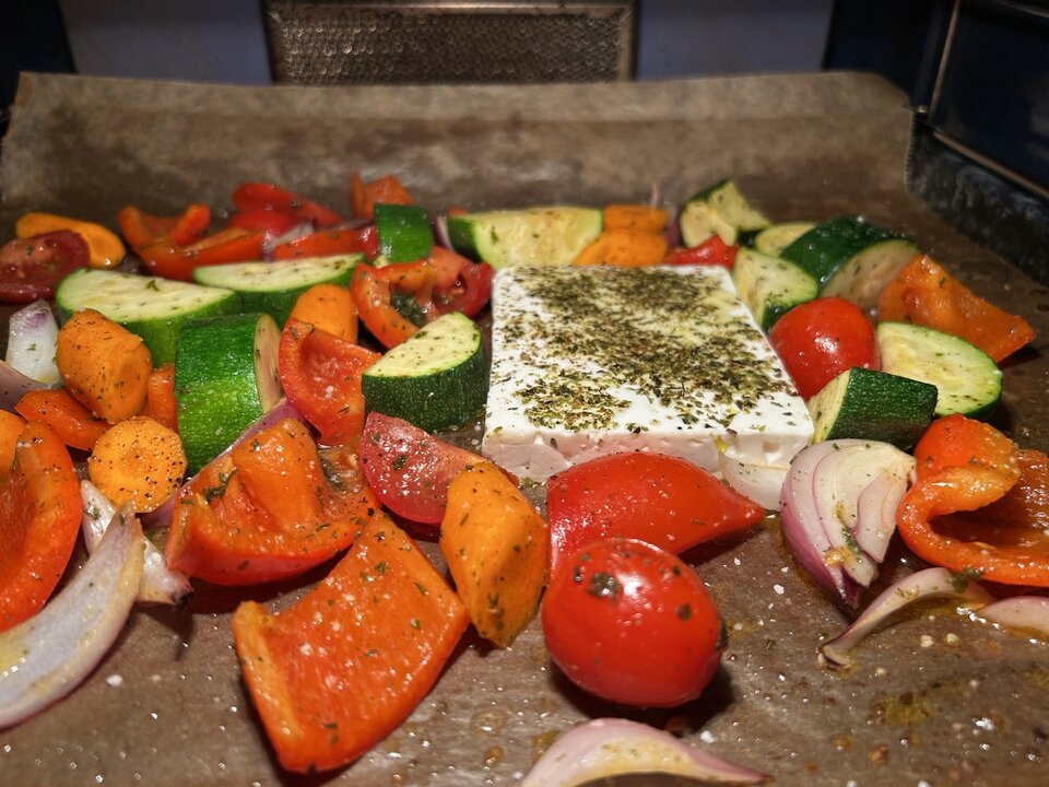 Vorbereitetes mediterranes Gemüse mit Feta auf einem Backblech